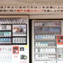 两台嵌在店面中的日本香烟自动售货机，摆有 Marlboro、Lark、Seven Stars 和 Hope 香烟，每台均配有红色 taspo 年龄验证读卡器