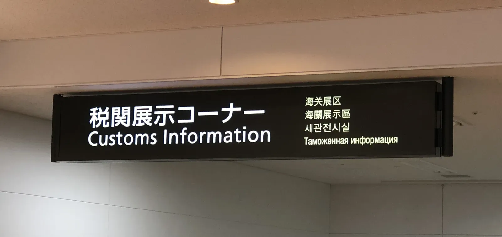 Multilingual customs information sign reading 税関展示コーナー / Customs Information in Japanese, Chinese, Korean and Russian at a Japanese international airport