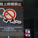 Shinjuku街头标志，写有“路上喫煙禁止”，带划掉香烟的图案，以及英文“Smoking on the street is prohibited”
