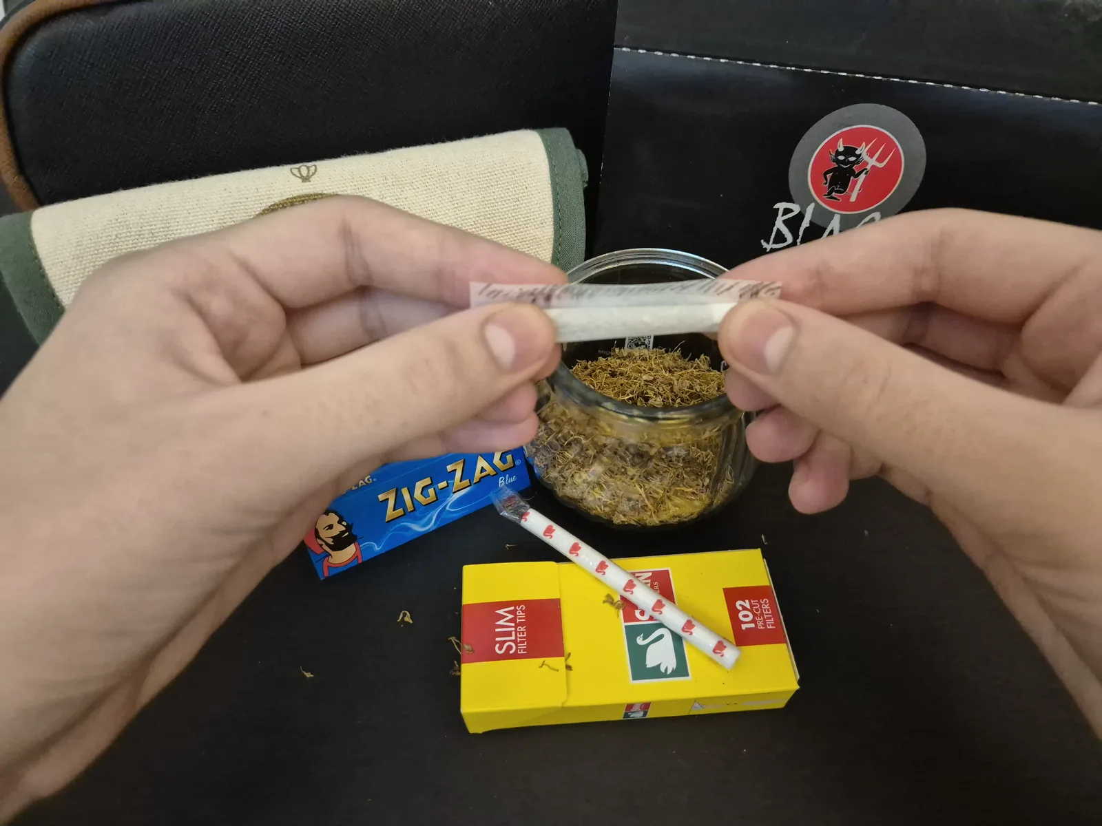 糊の線まで巻き、継ぎ目を閉じる前に糊を舐めている