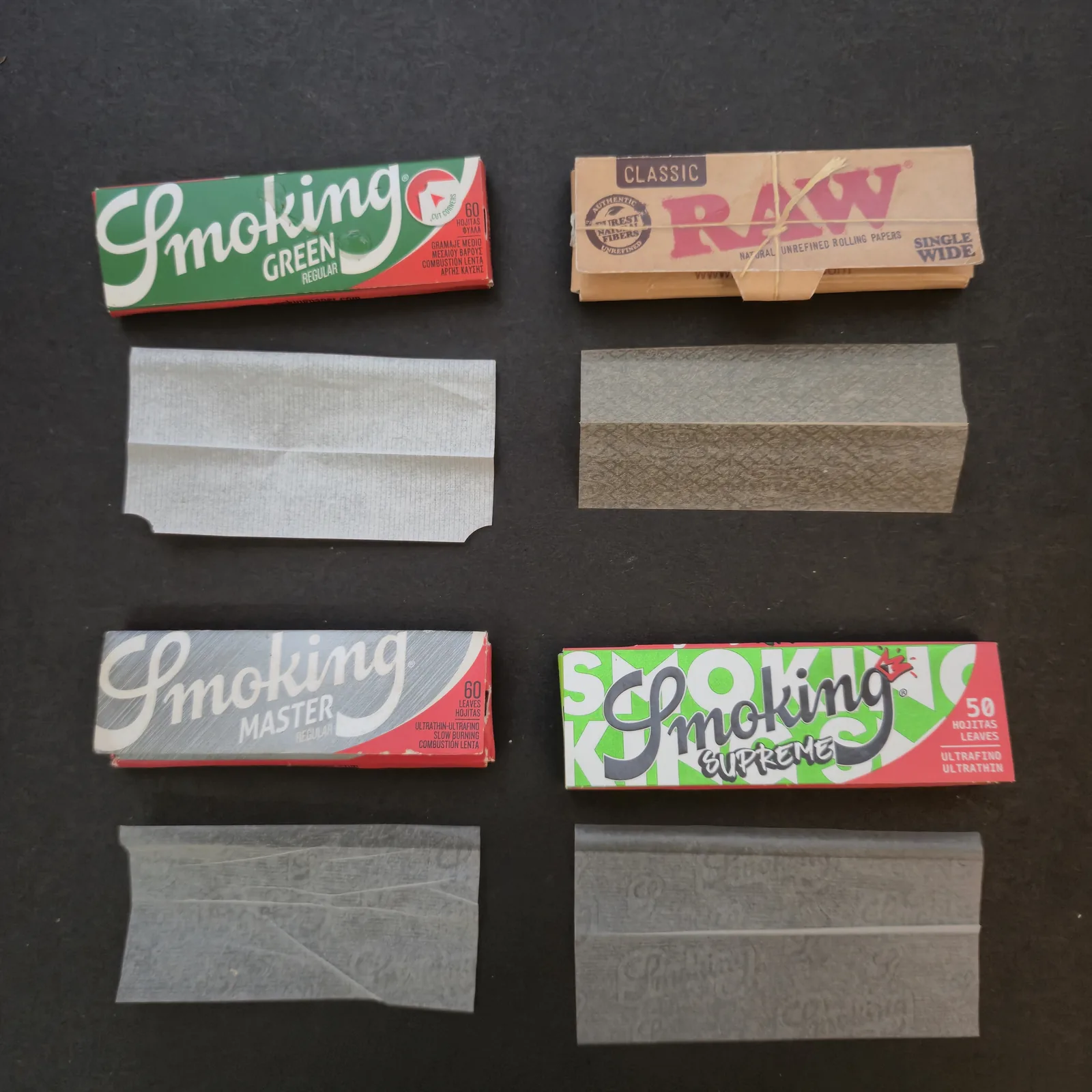 広げた紙を添えた4冊のペーパー。ヘンプのRAW Classicと、厚さの違うパルプのペーパー3種