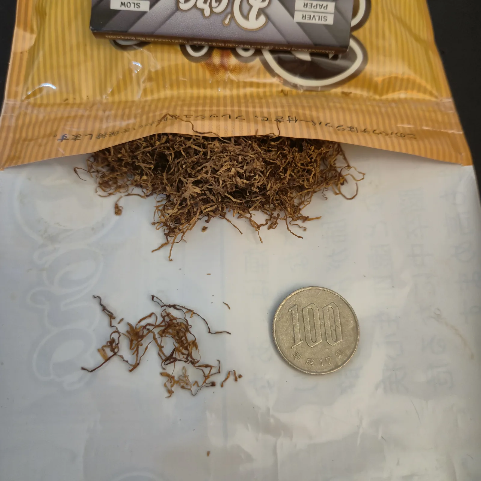 シャグの刻みのマクロ撮影。繊維の一本一本が見える。大きさ比較用の100円玉