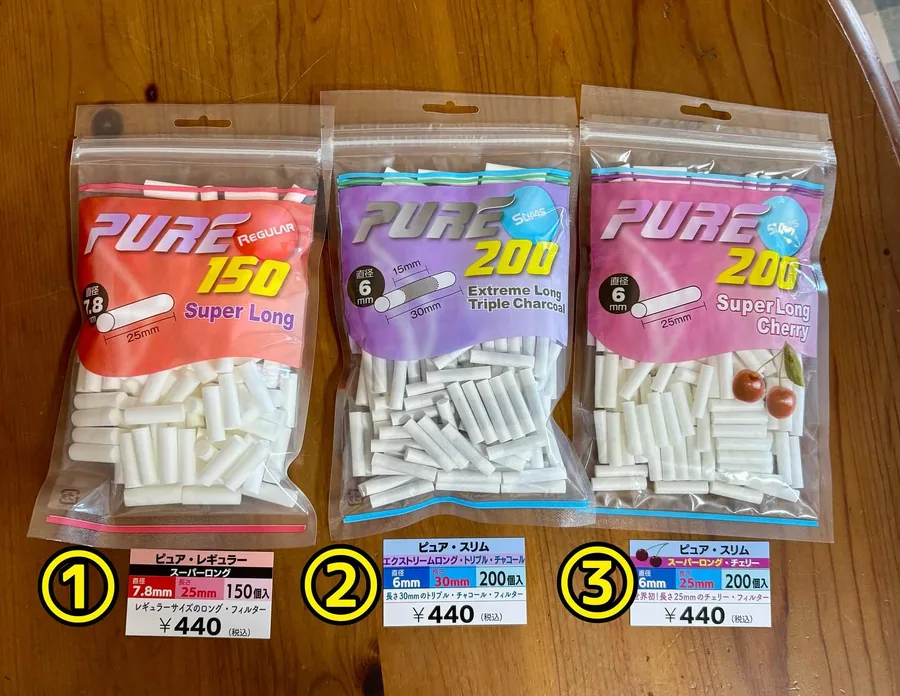 나무 테이블 위에 ①부터 ③까지 번호가 붙은 PURE 롤링 필터 3봉지 — Regular Super Long, Extreme Long Triple Charcoal, Super Long Cherry — Himawari Tobacco Shop, Tsuruga