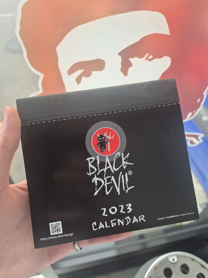 Black Devil branded 2023 calendar on the shop wall — KONYA Tobacco House, Kushiro, Hokkaido