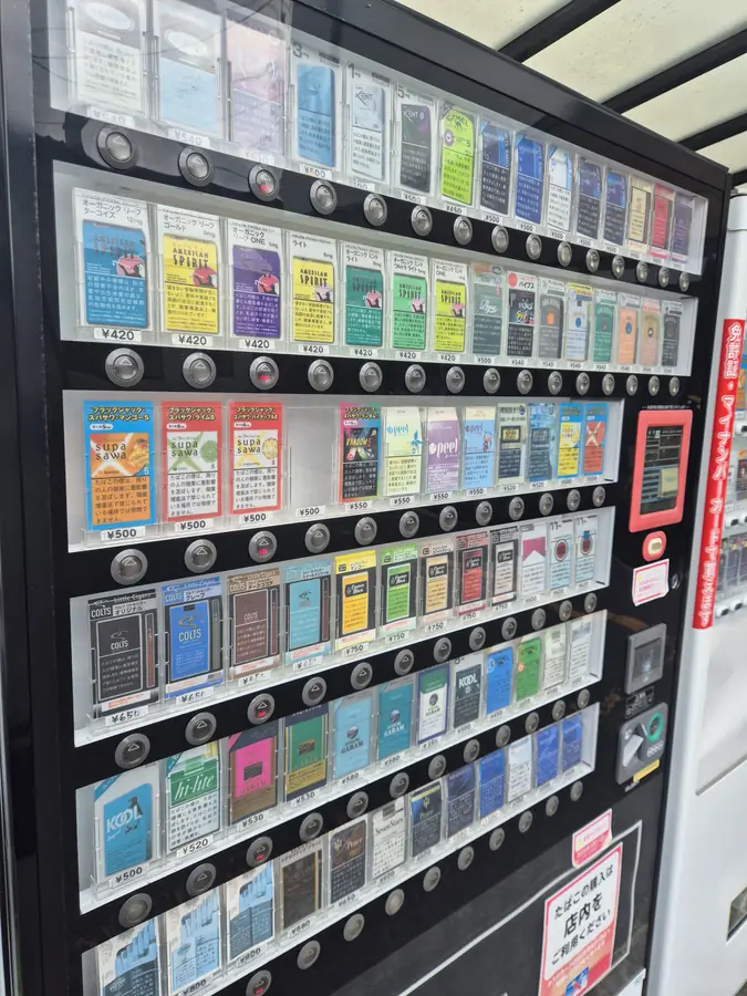 Cigarette vending machine by the shop entrance, stocked with rare Japanese brands — KONYA Tobacco House, Kushiro, Hokkaido