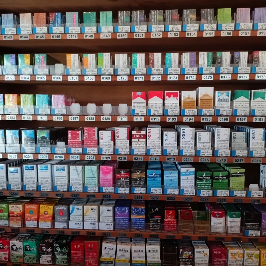 궐련 진열벽의 다른 부분 — Marlboro, Lark, Philip Morris와 中華, 中南海 같은 중국 브랜드 — 맨 위 선반에는 궐련형 전자담배용 스틱 — T-Shop Tobacco, Akashi